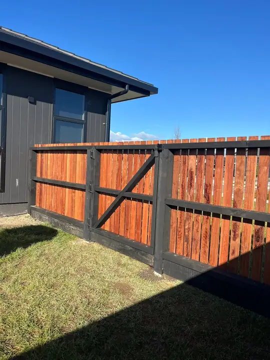 Stained timber fence with black posts