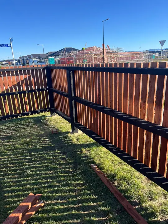 Corner timber fence with black rails
