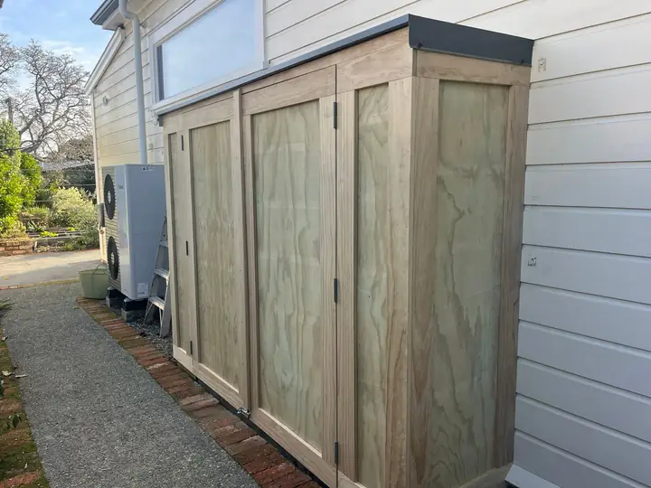 Timber storage shed against a house